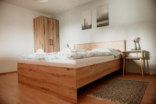 彼得罗瓦茨纳米拉维Vikendica Castanea Banja Ždrelo的卧室内的木床,配有床头柜和桌子