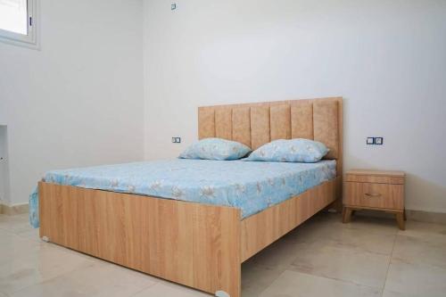 哈马马特Apt 5min de la zone touristique的一间卧室配有一张大木床和蓝色床单