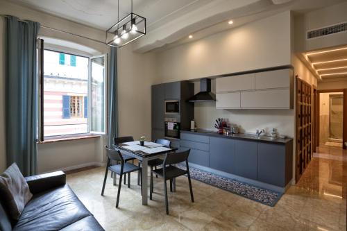 热那亚Le Due Piazze的厨房以及带桌椅的用餐室。