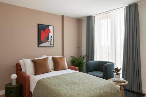 利物浦Cove Paradise Street的卧室配有床、椅子和窗户。