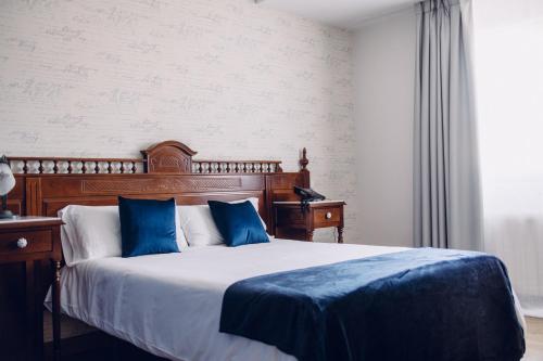Viveda雀利酒店的一间卧室配有一张带蓝色枕头的大床