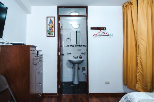 库斯科Casa de Laura的浴室配有盥洗盆和带镜子的淋浴
