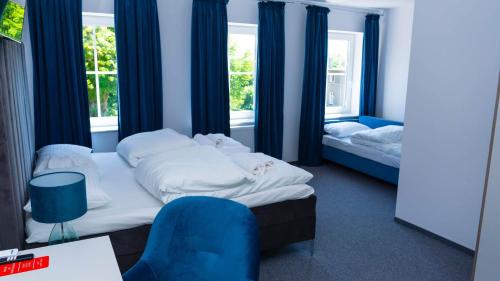 布热格Bon Żur的一间卧室配有两张床和一张蓝色椅子