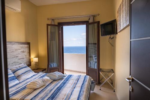 PanayíaTheoxenia Kasos Luxury Apartments的一间卧室设有一张床,享有海景