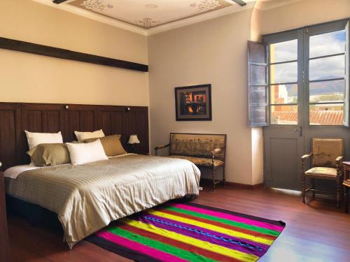 塔里哈Casona Gloria的一间卧室配有一张大床和色彩缤纷的地毯。