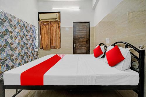 孟买OYO Flagship Raj Hotel Near Juhu Beach的一间卧室配有红色和白色枕头的床