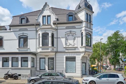 不莱梅Charmante Altbremer Wohnung I Wintergarten I Küche I Balkon的街道上一座白色的建筑,有钟楼