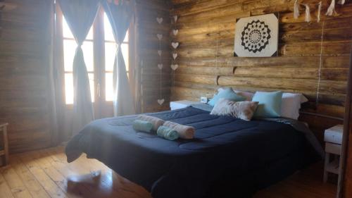 乌斯帕亚塔cabañas de montaña的一间带一张大床的卧室,位于带木墙的房间