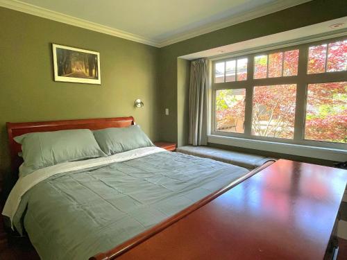 温哥华Elegant, Sunny Modern Home with Skylights - Kitsilano, Vancouver的一间卧室设有一张床和两个窗户。