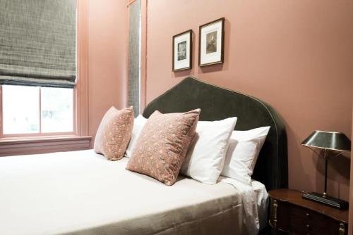 查尔斯顿The Juliette - Luxury Historic Residence的卧室配有带白色枕头的床和窗户。
