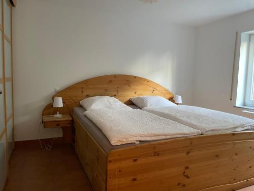 柯尼希斯温特Büchling FEWO的卧室内的木床,配有木制床头板