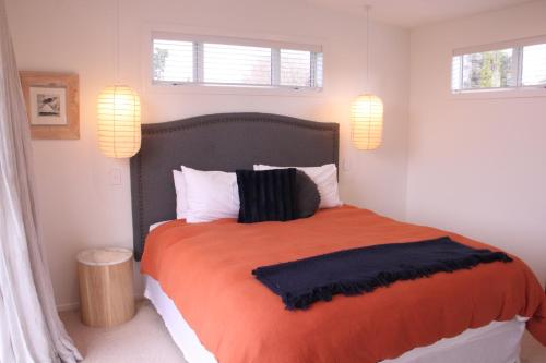北哈夫洛克Sublime Nooks的一间卧室配有一张大橙色床和两个窗户