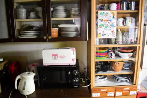 别府OMOLOSO Hostel　オモロソウ ホステル的厨房配有咖啡机和微波炉。