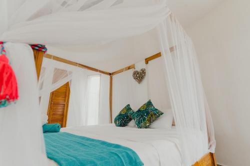 帕洛米诺UUTTAAKA Eco-Hotel的一间卧室配有一张带天蓬的白色床