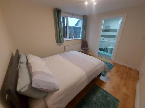 蒂厄姆West coast countryside escape的一间卧室配有一张带白色床单的床和一扇窗户。