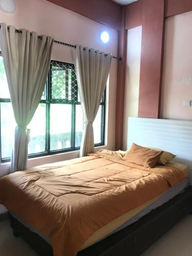 庞卡兰布翁Bubuhan Kita Guest House Syariah的一间卧室设有一张大床和窗户