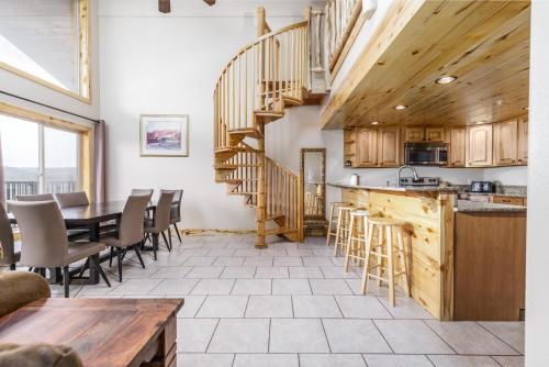 达克科里克村小鸭溪度假屋的一间厨房和带木制螺旋楼梯的用餐室