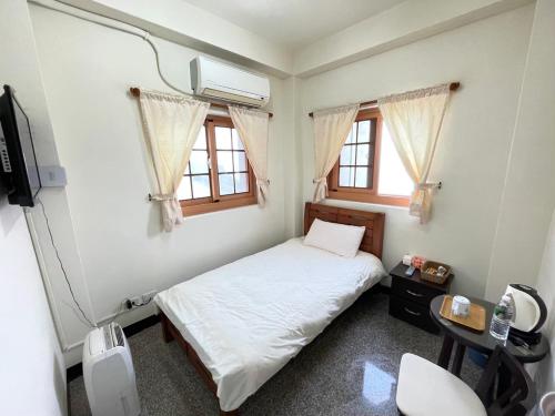 北竿芹壁山城民宿 Chinbe Hill Village House B&B的一间卧室设有一张床、一台电视和窗户。