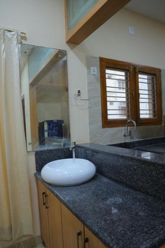 蒂鲁帕蒂Padma Homes Stay- Luxury Service Apartment 1BHK & 2BHK & 3BHK的浴室的柜台设有水槽和镜子