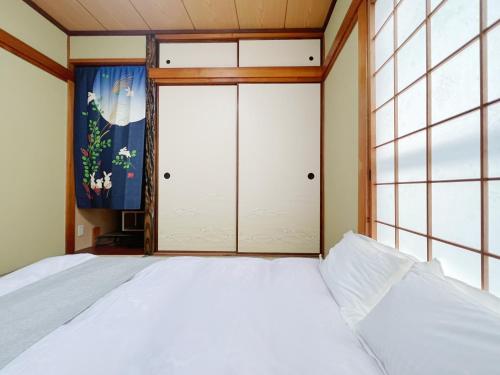 东大阪市千間川－久宝寺的一间卧室设有一张床和大窗户
