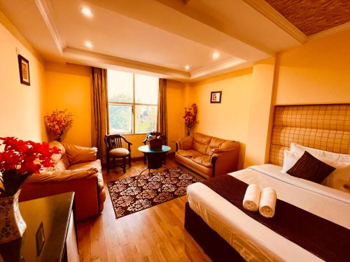 哈里瓦Rio Classic, Top Rated & Most Awarded Property in Haridwar的酒店客房带两张床和一个客厅
