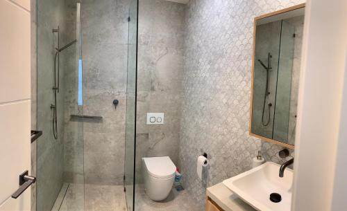 黄金海岸Karma Villas的带淋浴、卫生间和盥洗盆的浴室
