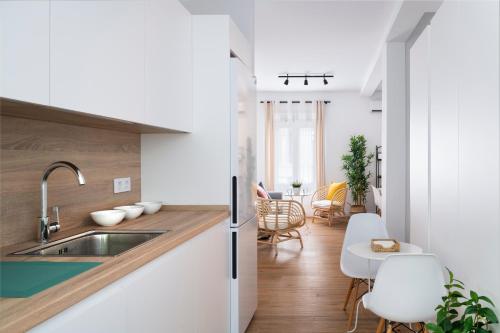 塞维利亚Magno Apartments Miño的厨房配有水槽和桌椅