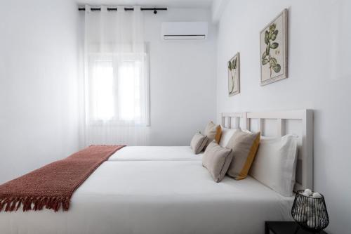 塞维利亚Magno Apartments Miño的白色卧室配有一张带枕头的大白色床