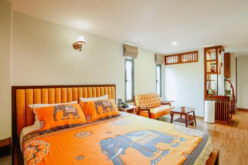清迈WangChang Hotel Chiang Mai โรงแรมวังช้าง เชียงใหม่的一间卧室配有一张带橙色枕头的大床