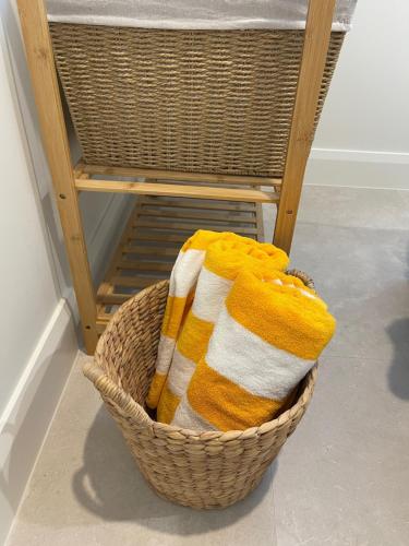 拜伦湾Sunny Palm Cottage Byron Bay - Brand New的椅子旁的毛巾篮