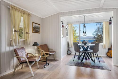 波多Hytte i Saltstraumen的一间带桌椅和窗户的用餐室
