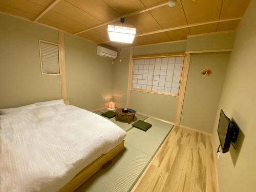 下吕市Toraya的一间卧室配有一张床和一台电视。