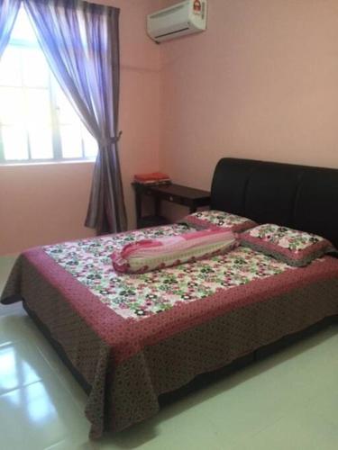 CukaiD'FIEZA HOMESTAY KEMAMAN的床上的床上有鲜花床罩