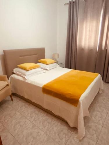 普拉亚Apartamento Siomaly - Piscina的一间卧室配有一张带黄色枕头的大床