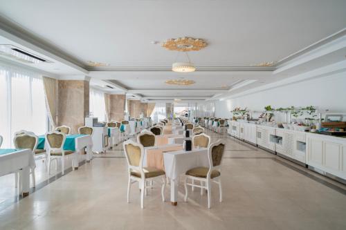 安塔利亚SL La Perla Hotel Kemer的一间设有白色桌椅的用餐室