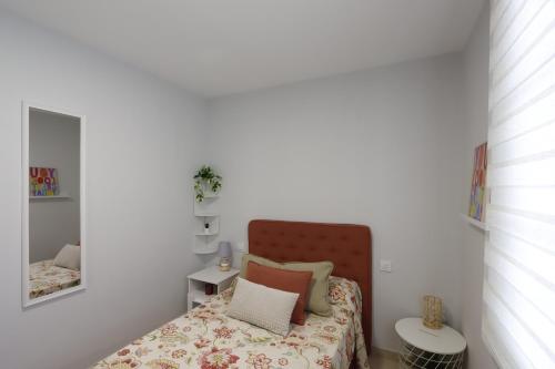 里瓦德奥Casa Flor Delfin Ribadeo的一间小卧室,配有一张床和镜子