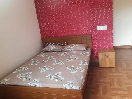 KakkabePaadi Inn的一间小卧室,配有一张床和红色的墙壁