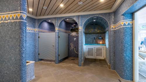 奥伯斯特多夫Alpenhotel Oberstdorf - ein Rovell Hotel的浴室设有蓝色瓷砖墙壁和淋浴。