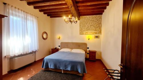 Pegognaga沃利维亚瑞莱斯住宿加早餐旅馆的一间卧室配有一张带蓝色毯子的床和窗户。