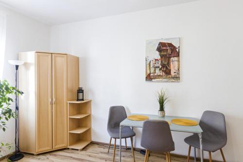 格但斯克Apartament 2 pokojowy Gdańsk的一间带桌椅和橱柜的用餐室