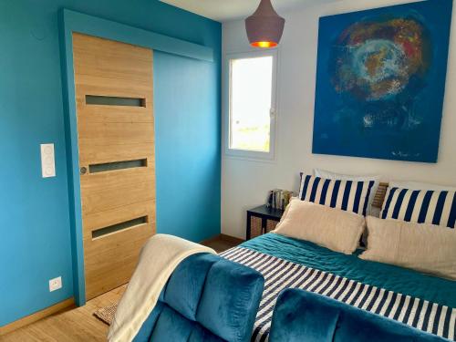 卡布尔Joli studio près du front de mer的一间卧室设有一张床和蓝色的墙壁