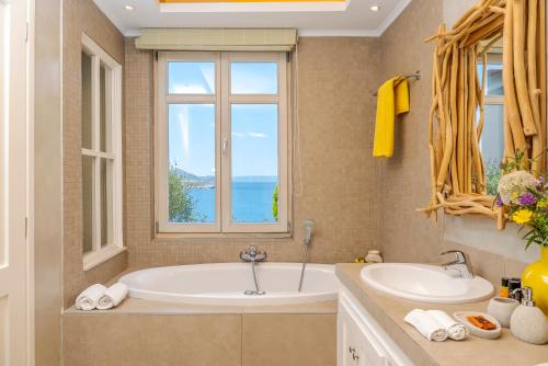 阿尔米里达SK Place Luxury Seafront Villas Chania的带浴缸、水槽和窗户的浴室