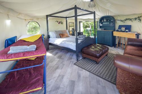 巴罗弗内斯West Point Woods的帐篷内的卧室,配有一张床和一张书桌