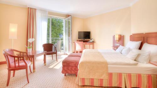赛巴特班森Hotel zur Post - ein Rovell Hotel的酒店客房设有一张大床、一张桌子和一张桌子。