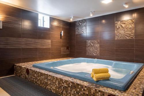 里加Bellevue Park Hotel Riga with FREE Parking的浴室设有大浴缸,内配黄毛巾