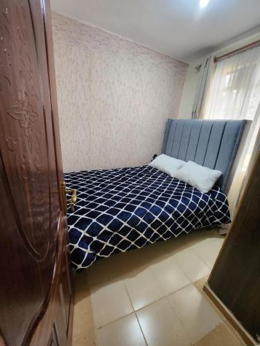 KagioZuri homes 1的一间小卧室,房间内设有一张蓝色的床