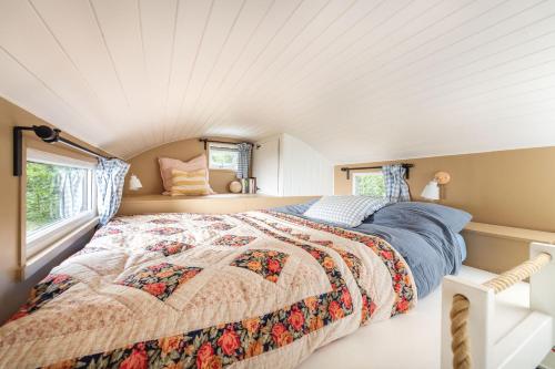 博德明Fleur de Grog - Shepherds Hut的一间卧室设有一张床和两个窗户。