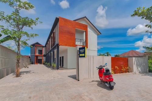 TumbangrunganUrbanview Hotel Griya Menteng Palangkaraya by RedDoorz的停在房子前面的一辆红色摩托车