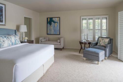 奥兰多Hyatt Regency Grand Cypress Resort的卧室配有一张白色大床和两把椅子