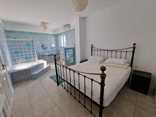 EpiskopianáOlive Villa的一间卧室配有一张床、一个浴缸和一个水槽